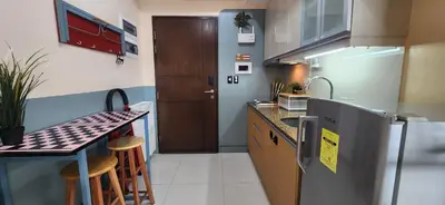 a small kitchen with a counter and a refrigerator at 22e BGC Unit 3 mins Walk to The Venice Grand Canal Mall Pet Friendly in Manila