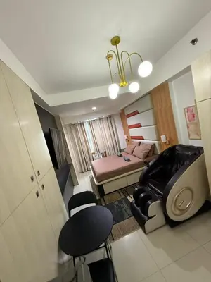 a room with a bedroom with a bed and a chair at Staycation By ABBYBI in Manila
