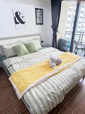 a bedroom with a bed with a yellow comforter at Sy bay suites beside okada manila near MOA COD T3 MSV2117H in Manila