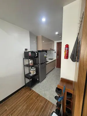 a small kitchen with a refrigerator and a counter at Sy bay suites beside okada manila near MOA COD T3 MSV2117H in Manila