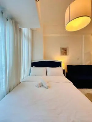 a white bed in a room with a large window at The Serene Studio by Kozy Mood in Manila