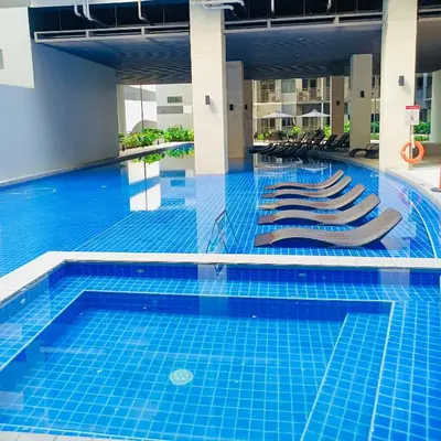 a swimming pool with lounge chairs in a building at Seren View Bedspace - S Residences in Manila
