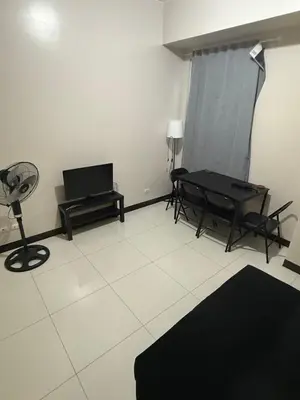 a living room with a table and a fan at 101 Newport Boulevard Pasay City Condotel in Manila