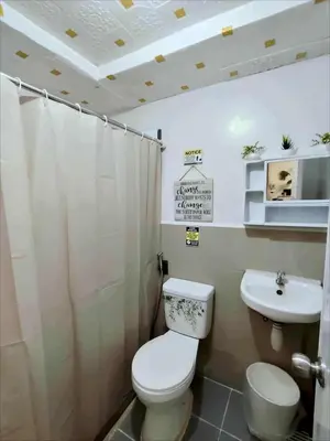 a bathroom with a toilet and a sink at Staycation at Brgy Cupang in Manila