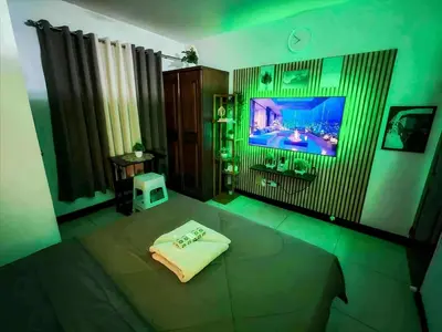 a bedroom with a bed with a tv on the wall at Staycation at Brgy Cupang in Manila