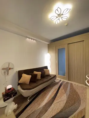 a living room with a couch in the middle of a room at The Chill Lane- Shore Residences in Manila