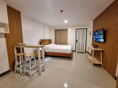 a bedroom with a bed and a desk and a table at Flat 35, Unit E in Manila