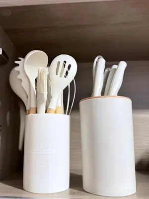 two white containers filled with utensils on a shelf at Cami Haus at Fame Residences in Manila
