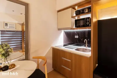 a small kitchen with a sink and a microwave at Near Venice Mall! Hotel 1BR Unit in Viceroy Residences in Manila