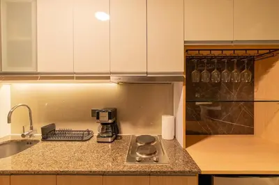 a kitchen with a counter top with a coffee maker at Amazing View - Cozy 1BR at One Eastwood with Washer High Speed Wi-Fi in Manila