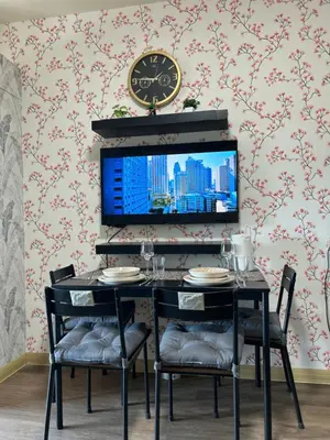 a dining room with a table and a clock on the wall at Family Condo SMB in Manila