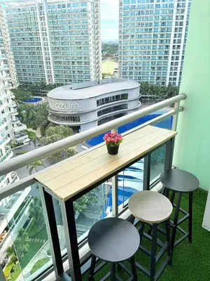 a balcony with a wooden table and two stools at Azure Staycation by Casa Tremora Deluxe in Manila