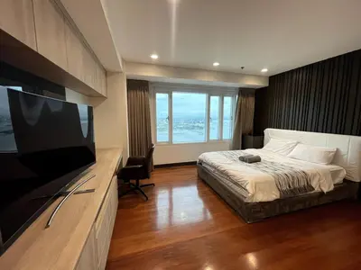 a bedroom with a bed and a flat screen tv at Ultra Luxury 5BR Penthouse in Manila Bay Rizal Park in Manila