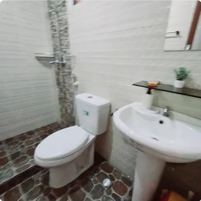 a bathroom with a white toilet and a sink at Greenhills Garden Square Residences 2BR & 2 Toilets Quezon City in Manila