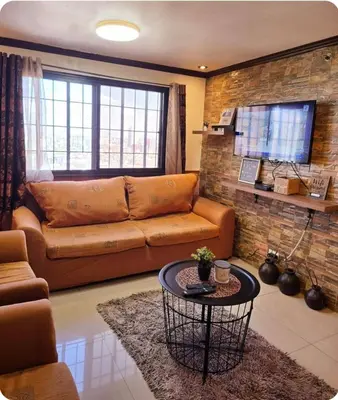 a living room with a couch and a table at Greenhills Garden Square Residences 2BR & 2 Toilets Quezon City in Manila