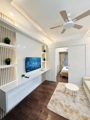 a living room with a couch and a tv at Luxurious Room in Bel Air Makati - Air Residences in Manila