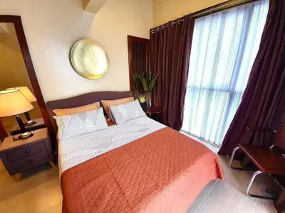 a bedroom with a large bed and a large window at Staycation in Brgy Cupang in Manila