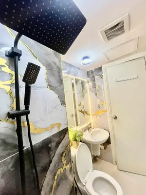 a bathroom with a toilet and a black umbrella at Azure Staycation by Cm in Manila