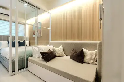 a bedroom with a bed and a couch with pillows at Hotel Comfort FREE Parking Fame Mall Access in Manila