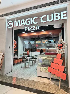 a magic cube pizza shop with red chairs in front of it at Hotel Comfort FREE Parking Fame Mall Access in Manila