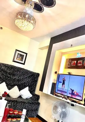 a living room with a flat screen tv and a couch at 1 Br - Royalty Vacation - Edsa Makati in Manila
