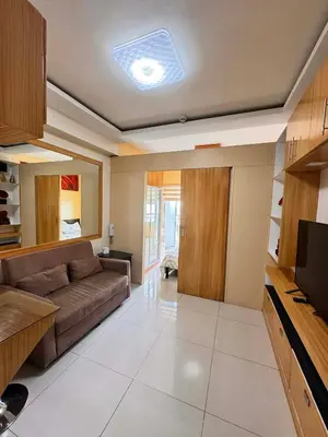 a living room with a couch and a tv at Kitty Breeze Staycation in Manila
