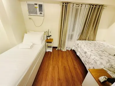 a small bedroom with a bed and a wooden floor at The Camden Place Aesthetic Elegant Condo Unit 15 in Manila