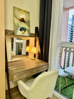 a desk with a white chair and a mirror at Cozy Apartment in Venice Luxury Residences BGC in Manila