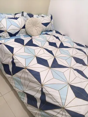 a bed with a blue and white comforter and pillows at Terra Nueve Escape - 1br with Balcony Staycation in Manila