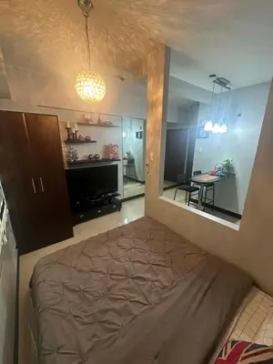 a bedroom with a bed and a dining room at Jazzy Flat in Manila