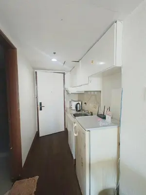a small kitchen with white cabinets and a counter top at Ancalm condon in Manila