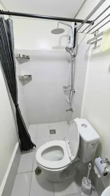 a small bathroom with a toilet and a shower at City View with Balcony at Kasara Residences C5 Pasig in Manila