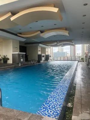 a swimming pool on the roof of a building at JFS Staycation at Birch Tower - Cozy Home in Manila