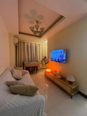 a living room with a couch and a flat screen tv at JFS Staycation at Birch Tower - Cozy Home in Manila
