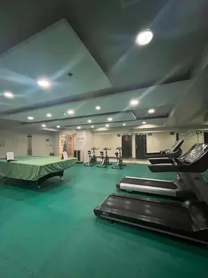 a gym with several treadmills and exercise bikes in it at JFS Staycation at Birch Tower - Cozy Home in Manila