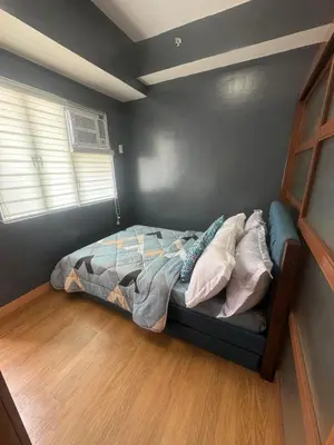 a bedroom with a bed in the corner of a room at Staycation by Purple Tree in Manila