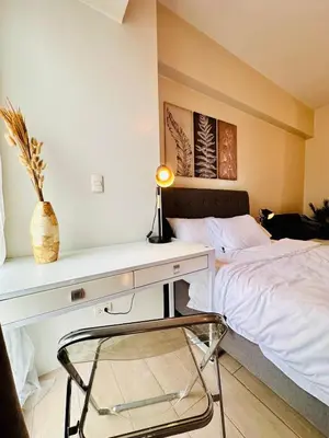 a bedroom with a bed and a desk with a lamp at 81 Newport Urban Chic Studio near NAIA Terminal 3 in Manila