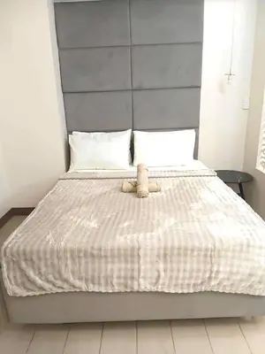 a bed with a teddy bear sitting on top of it at Casa Venice Rustic Pet Friendly Studio Balcony in Manila