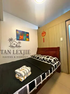 a bedroom with a bed with a sign on the wall at Tan LexJie Havens and Hideout in Manila
