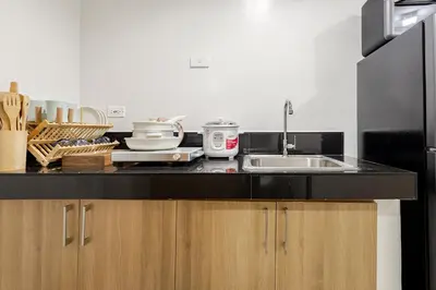 a kitchen with a sink and a counter top at Near SM BF & Shopwise SLEX Accessible 2BR for 4 in Manila