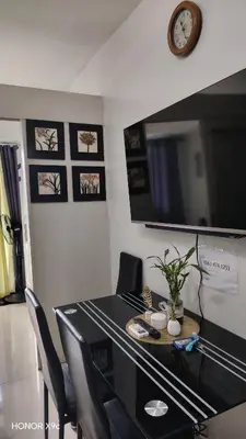 a dining room table with chairs and a clock on the wall at Moana SEA RESIDENCE condotel in Manila