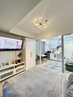 a bedroom with a large bed and a flat screen tv at Panglao Staycation in Manila
