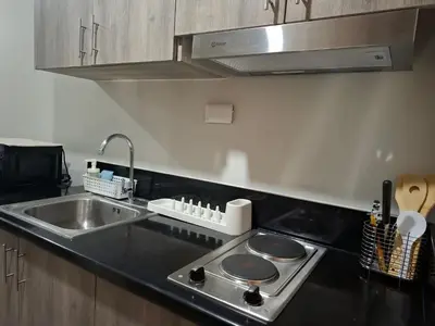 a kitchen with a sink and a stove top oven at S Residences MOA by darpm in Manila