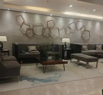 a living room with couches and a table and a wall at S Residences MOA by darpm in Manila
