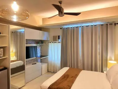 a bedroom with a bed and a ceiling fan at COZY COVE IN venice MCKINLEY HILL in Manila