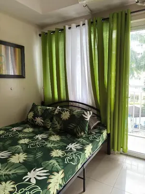 a couch in a room with green curtains at Ate Aby's Place 338 in Manila
