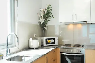 a kitchen counter with a microwave and a sink at Elegant 3 Bedroom unit with Ocean View near Okada in Manila