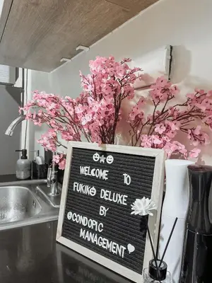 a sign sitting on a kitchen counter with pink flowers at Queen Bed with Coffee Bar and Fast Wi-Fi at S Residences in Manila