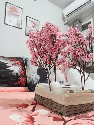 a table with pink flowers on a bed at Queen Bed with Coffee Bar and Fast Wi-Fi at S Residences in Manila
