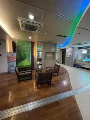 a lobby with two chairs and a large screen at The Serenity Tower 2011 in Manila